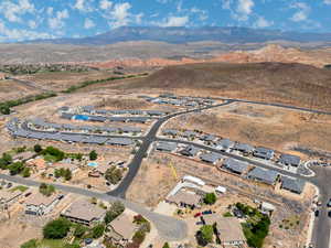 Aerial overview of property's location with a mountainous background and nearby suburban area