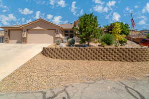 View of front of property with stucco siding, a garage, driveway, a tile roof, and stone siding