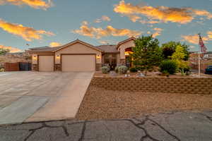 View of front facade featuring stone siding, an attached garage, stucco siding, concrete driveway, and a tile roof