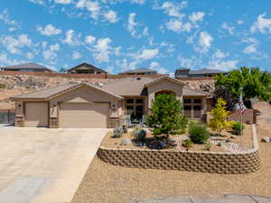 View of front of home featuring an attached garage, stone siding, stucco siding, driveway, and a tiled roof