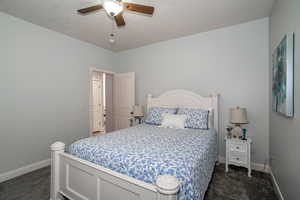 Bedroom 2 with dark carpet and a ceiling fan