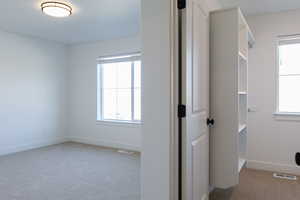 Hallway with carpet flooring and baseboards