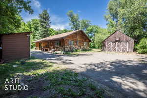 View of front facade with a garage, an outdoor structure, and a barn