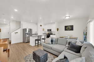 Living area featuring light wood-type flooring and recessed lighting