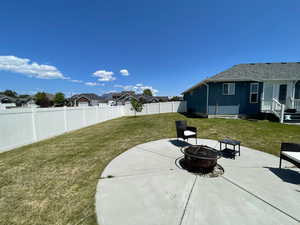 Fenced backyard featuring an outdoor fire pit, a patio, and a residential view