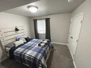 Basement Carpeted bedroom #1 featuring baseboards and a textured ceiling