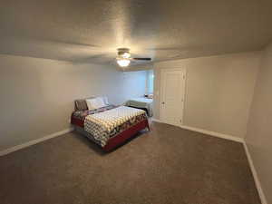 Bedroom #3 featuring dark colored carpet, a textured ceiling, and a ceiling fan