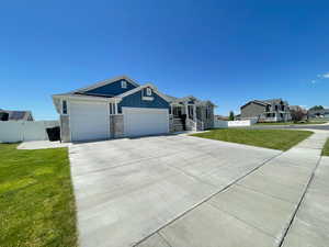 Rambler home with 3 car garage, concrete driveway, and board and batten siding
