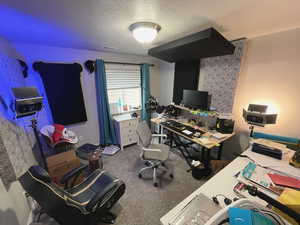 Carpeted home office/bedroom #2 with a textured ceiling