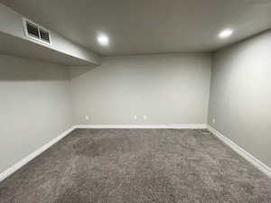 Finished basement featuring dark colored carpet and recessed lighting