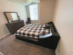 Upstairs bedroom featuring vaulted ceiling and baseboards