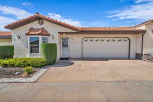 Mediterranean / spanish house featuring driveway, an attached garage, stucco siding, and a tiled roof