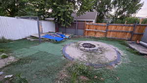 Fenced backyard featuring an outdoor fire pit