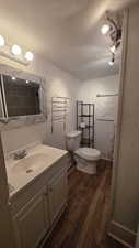 Full bath with wood finished floors, a textured ceiling, vanity, and a textured wall