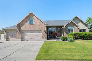 View of front of house featuring a front yard, brick siding, and driveway