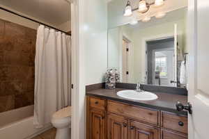 Full bathroom featuring vanity, shower / bathtub combination with curtain, and tile patterned floors