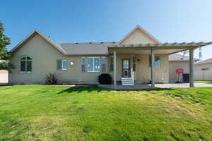 Rear view of house featuring entry steps, stucco siding, a patio area, and roof with shingles