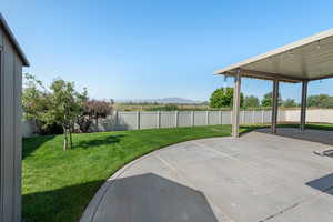 Fenced backyard featuring a patio and a mountain view
