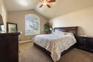 Carpeted bedroom featuring lofted ceiling and ceiling fan