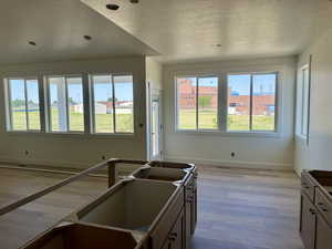 Kitchen featuring a textured ceiling, plenty of natural light, light wood-type flooring, and recessed lighting