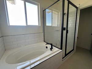 Full bath with a bath and a shower stall