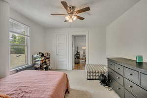 Carpeted bedroom with a ceiling fan