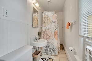 Full bath featuring tile patterned flooring and a shower with curtain