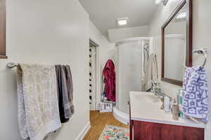 Bathroom featuring vanity, a shower stall, and wood finished floors