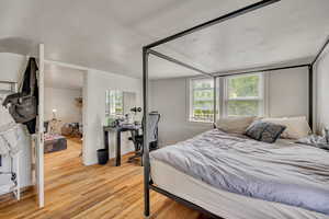 Bedroom featuring light wood finished floors and a desk
