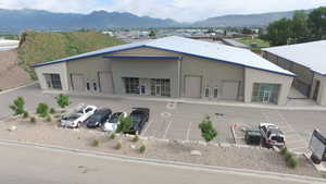 Rear view of property with a mountain view and uncovered parking