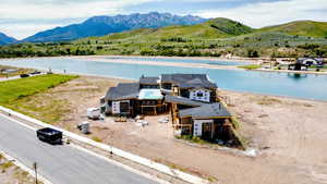 Aerial view of property and surrounding area with a water and mountain view