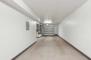 Garage with electric panel and baseboards