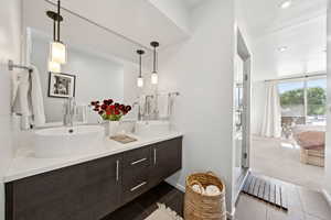 Ensuite bathroom with double vanity, a stall shower, and recessed lighting