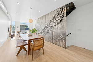 Dining space with wood finished floors and recessed lighting