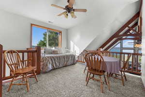 Bedroom featuring carpet, lofted ceiling, and a ceiling fan