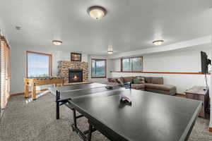 Rec room featuring carpet and a fireplace