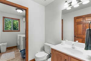 Bathroom featuring independent washer and dryer, vanity, and tile patterned flooring