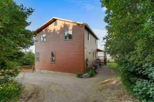 View of property exterior featuring dirt driveway and a central air condition unit