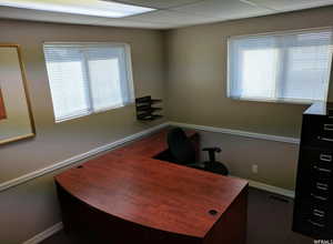 Office with baseboards and a drop ceiling