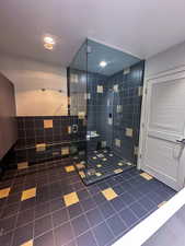 Bathroom featuring tile patterned floors and a stall shower