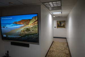 Corridor featuring a drop ceiling and carpet flooring