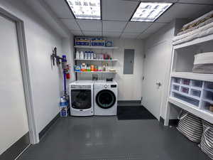 Laundry room featuring electric panel and separate washer and dryer