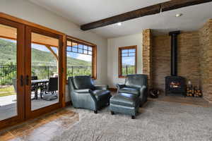 Living area featuring a wood stove, french doors, beamed ceiling, a mountain view, and recessed lighting