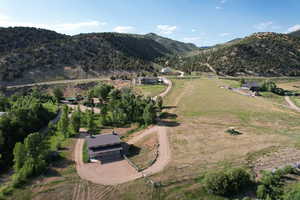 Aerial view; horse barn in foreground; home in center background.