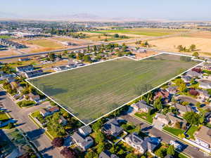 Aerial view of property and surrounding area featuring property parcel outlined and a mountainous background