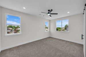 Unfurnished room with a barn door, carpet flooring, recessed lighting, and a ceiling fan