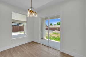 Unfurnished dining area featuring a chandelier and wood finished floors