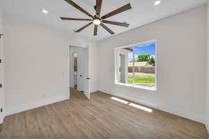 Spare room featuring light wood-type flooring, a ceiling fan, and recessed lighting