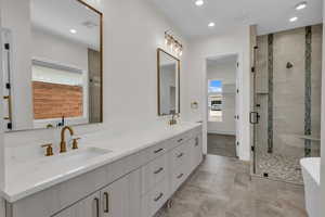 Bathroom with double vanity, a shower stall, a freestanding tub, recessed lighting, and marble finish flooring