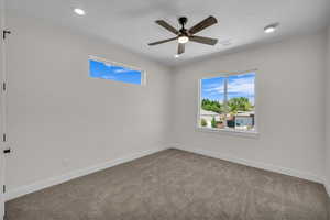 Carpeted spare room with healthy amount of natural light, ceiling fan, and recessed lighting